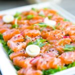 Salmon with greens and quail eggs on banquet table